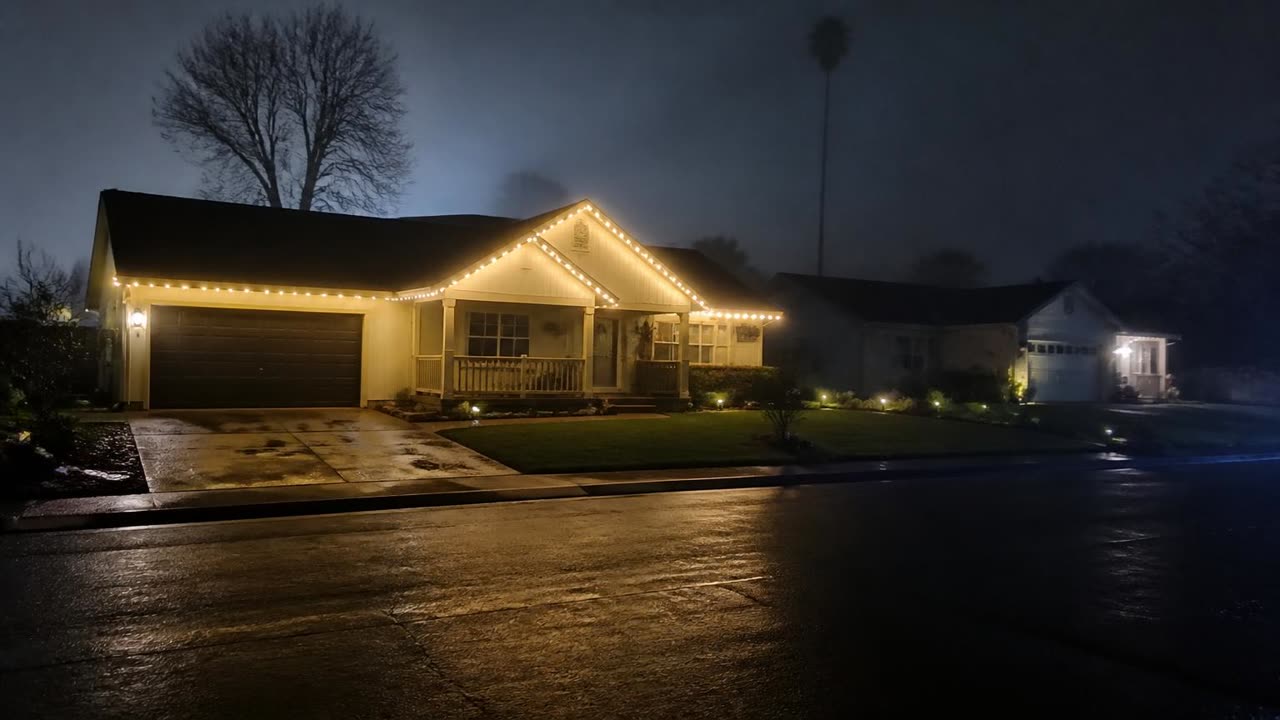 Escalon, CA street in Vintage Estates at night with permanent roofline lighting on a family home