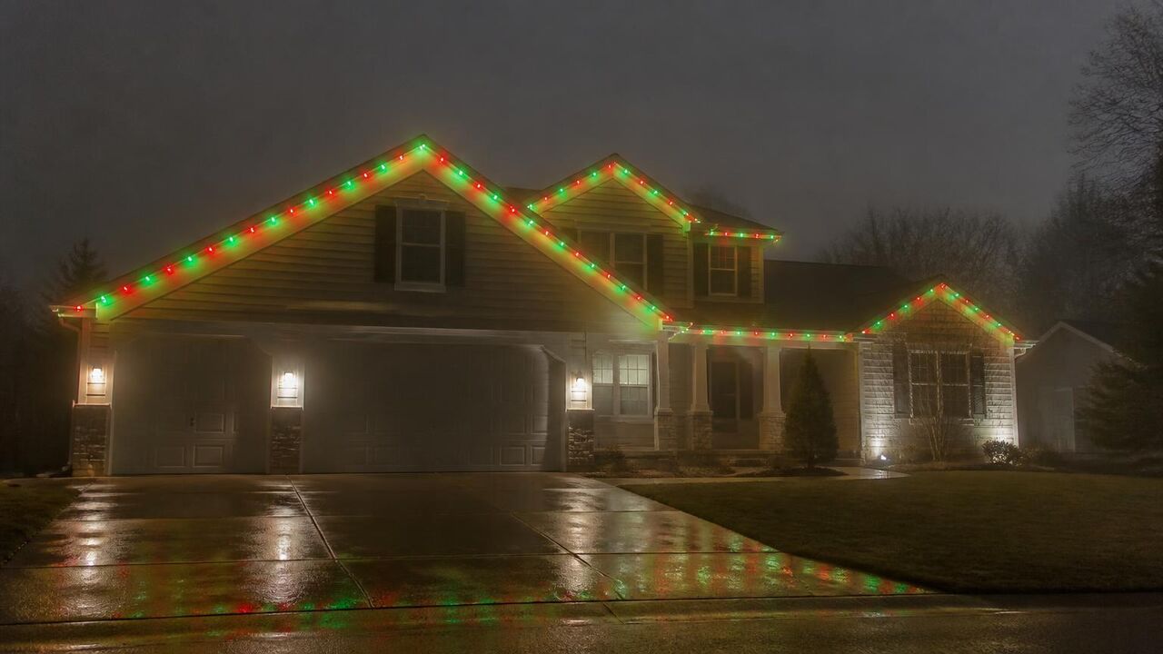 Lathrop home running red and green permanent Christmas lights on a foggy December evening