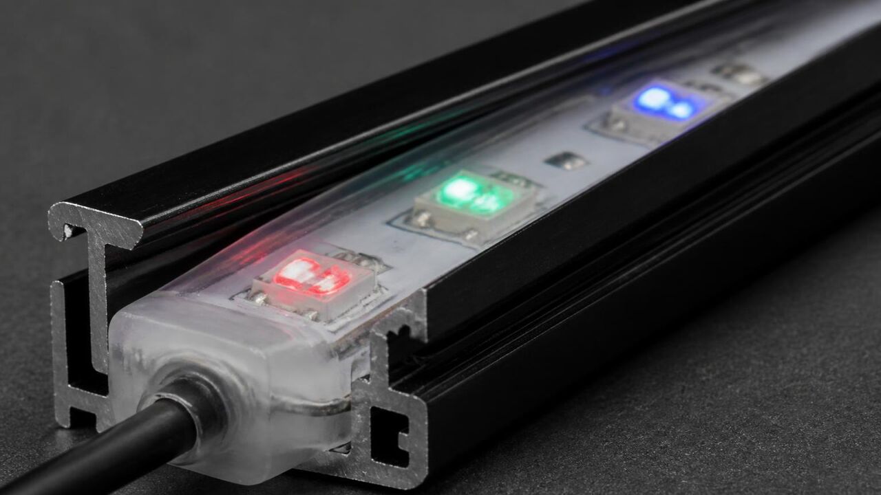 Macro photo of a weather sealed RGB LED module seated in the aluminum track used on Lathrop homes