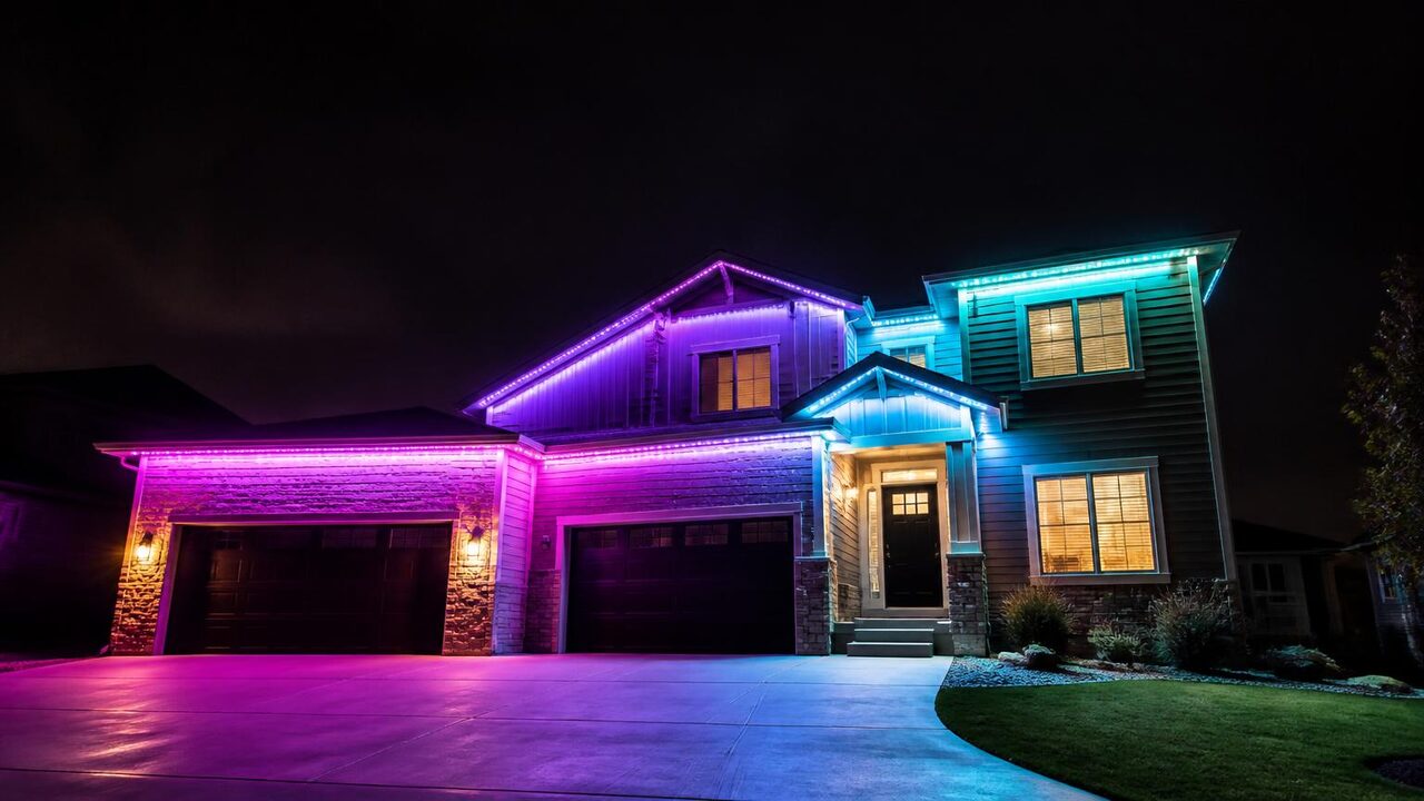 Permanent color changing house lights running a purple and teal gradient across the rooflines of a Manteca two-story home